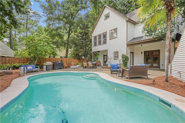 view of swimming pool with outdoor lounge area, french doors, and a patio area