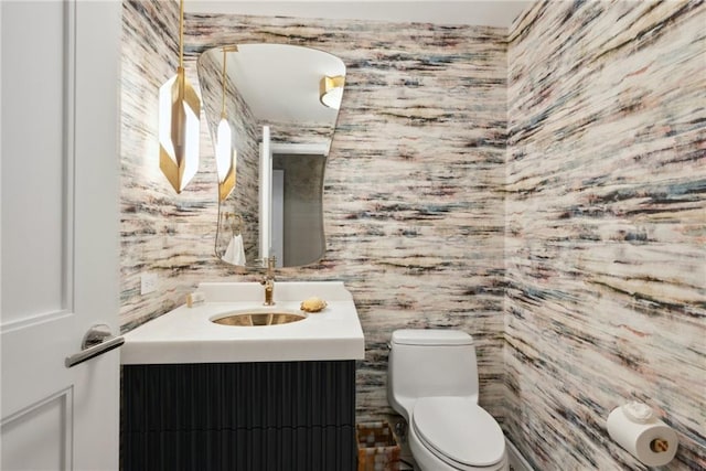 bathroom with vanity, toilet, and tile walls