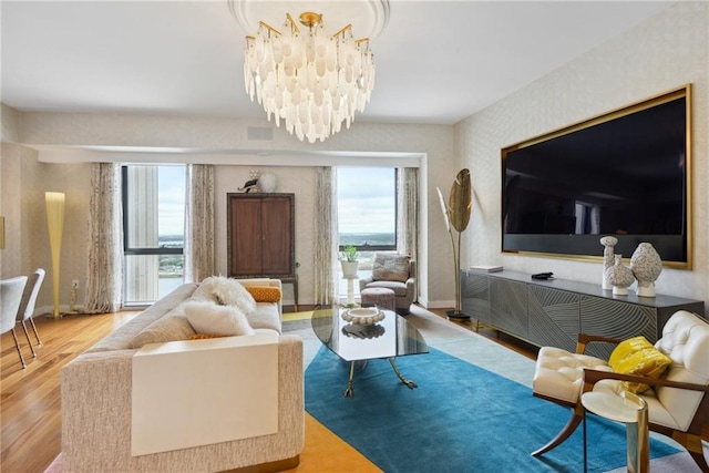 living room with light hardwood / wood-style floors and a notable chandelier