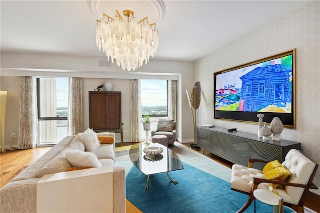 living area featuring hardwood / wood-style floors, a healthy amount of sunlight, and a chandelier