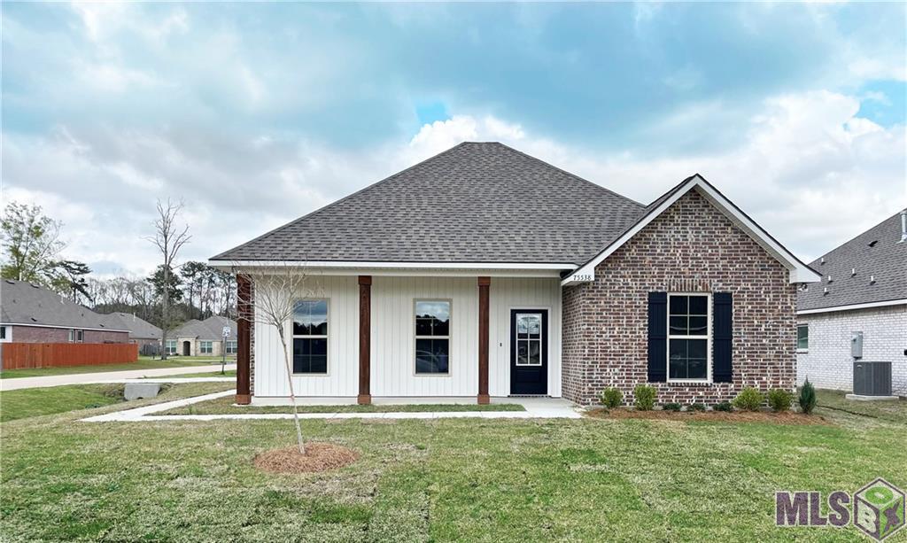 view of front of home featuring a front yard and central AC