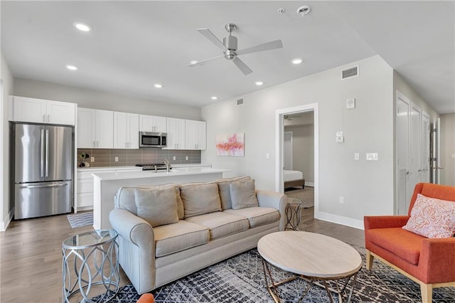 living room with sink, ceiling fan, and hardwood / wood-style floors