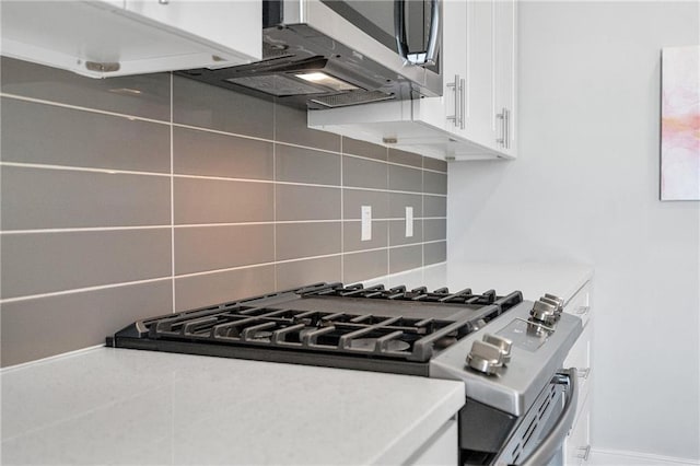 kitchen with backsplash, appliances with stainless steel finishes, and white cabinetry