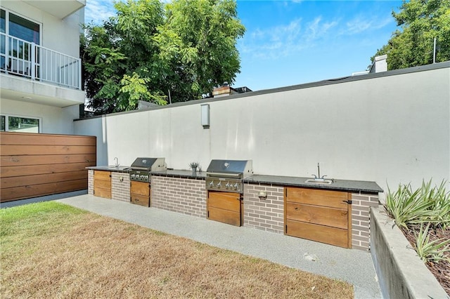 view of patio with grilling area, area for grilling, and a balcony