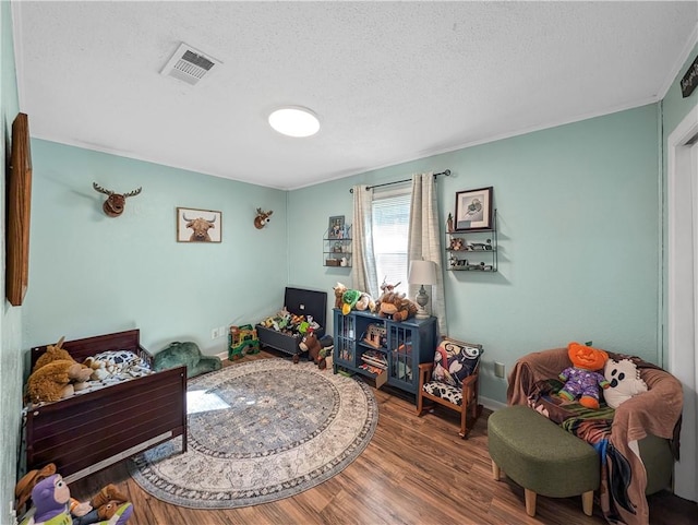 recreation room featuring hardwood / wood-style flooring and a textured ceiling