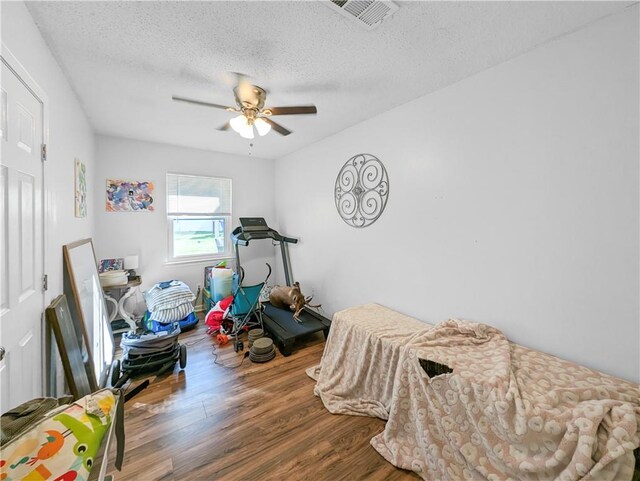 rec room featuring ceiling fan, hardwood / wood-style floors, and a textured ceiling