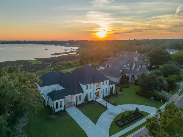 aerial view at dusk featuring a water view