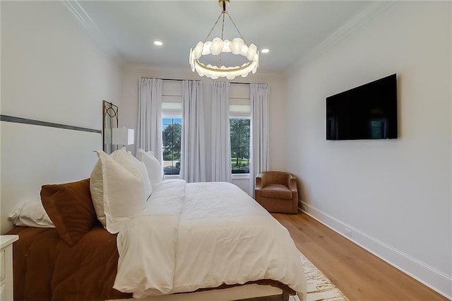 bedroom featuring ornamental molding, an inviting chandelier, and light hardwood / wood-style floors