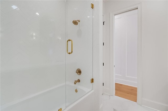 bathroom featuring enclosed tub / shower combo and hardwood / wood-style floors