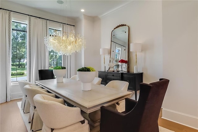 dining area featuring a notable chandelier, light hardwood / wood-style flooring, and ornamental molding