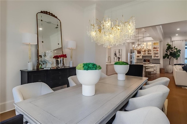 dining room with wood-type flooring, a notable chandelier, and ornamental molding