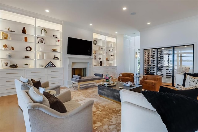 living room featuring light wood-type flooring, crown molding, and built in shelves