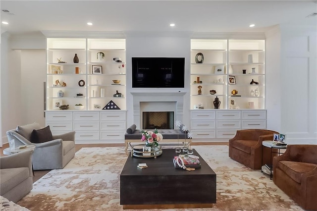 living room with ornamental molding and built in features