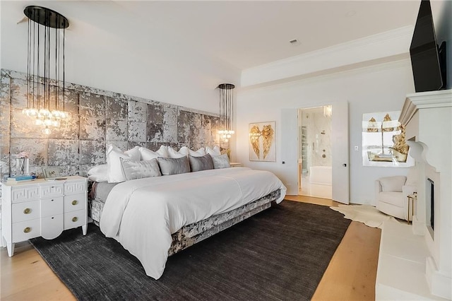 bedroom featuring ensuite bathroom, crown molding, and hardwood / wood-style floors