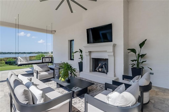 view of patio / terrace featuring ceiling fan and an outdoor living space with a fireplace