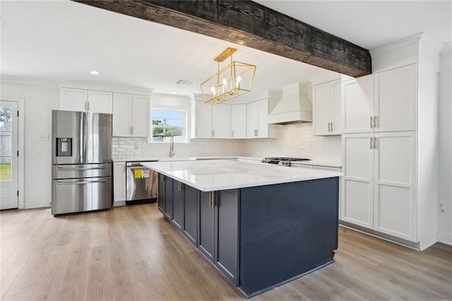 kitchen featuring premium range hood, pendant lighting, white cabinetry, light hardwood / wood-style flooring, and appliances with stainless steel finishes