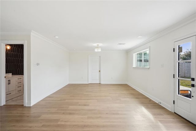 spare room featuring crown molding and light hardwood / wood-style floors