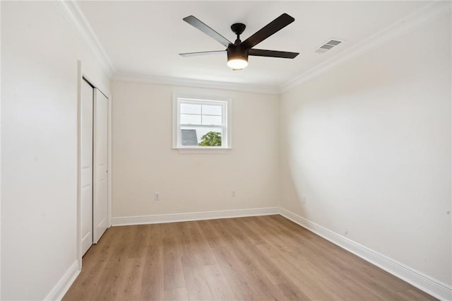 unfurnished bedroom with a closet, ornamental molding, light hardwood / wood-style floors, and ceiling fan