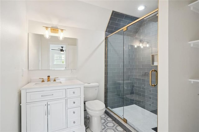 bathroom featuring ceiling fan, an enclosed shower, vanity, and toilet