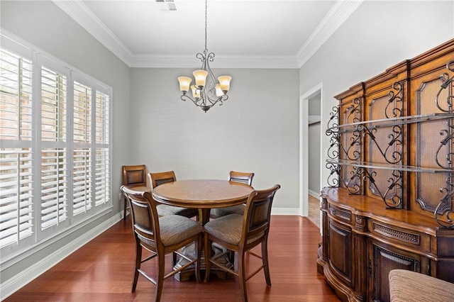 dining area with dark wood-type flooring, ornamental molding, and a chandelier