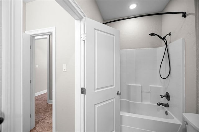 bathroom featuring tile patterned flooring, tub / shower combination, and toilet