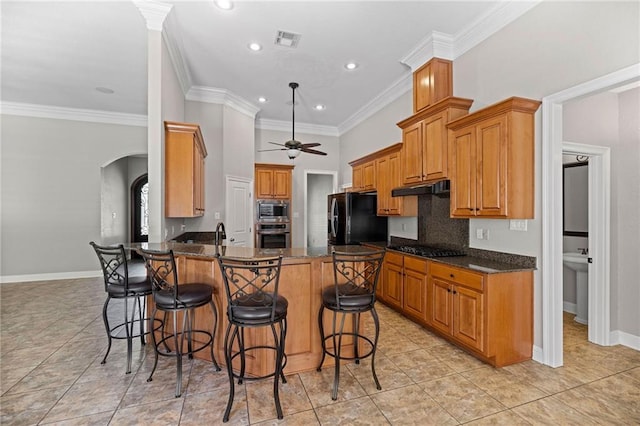 kitchen featuring ceiling fan, kitchen peninsula, black appliances, crown molding, and a kitchen bar