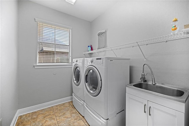 laundry room with light tile patterned floors, cabinets, sink, and washing machine and dryer