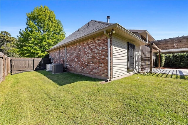 view of side of property featuring a lawn, a patio, and central AC