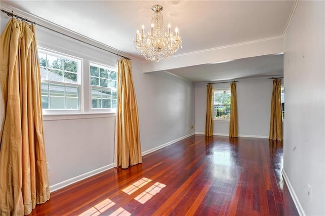 empty room featuring ornamental molding, an inviting chandelier, and dark hardwood / wood-style flooring