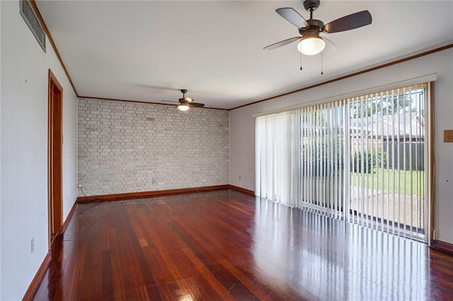 empty room featuring dark hardwood / wood-style floors, crown molding, brick wall, and ceiling fan