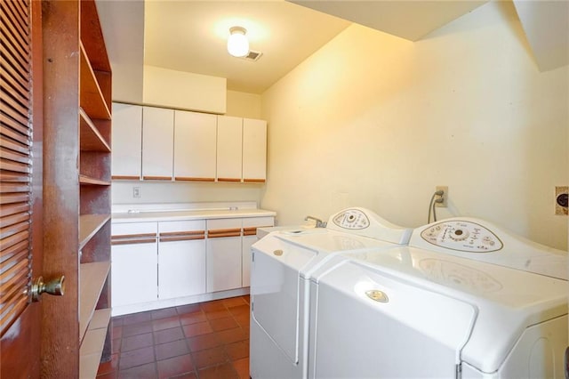 clothes washing area with washer and clothes dryer, cabinets, sink, and dark tile patterned floors