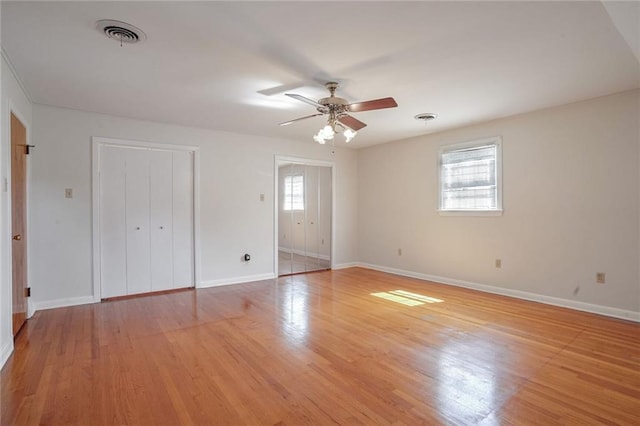 unfurnished bedroom with ceiling fan, light hardwood / wood-style flooring, and multiple windows