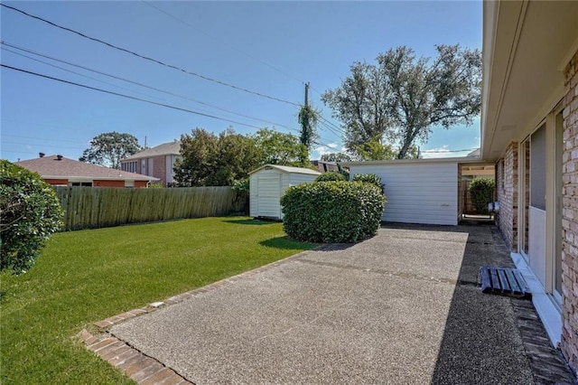 view of yard featuring a storage unit and a patio area