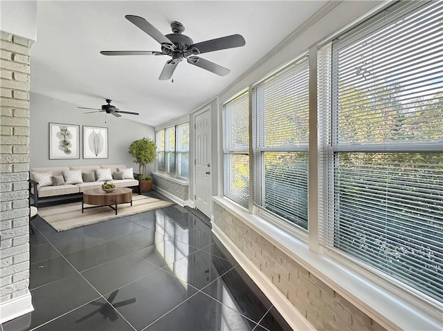 sunroom with ceiling fan and vaulted ceiling