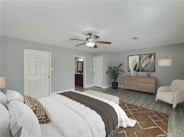 bedroom with ceiling fan, ensuite bath, and wood-type flooring