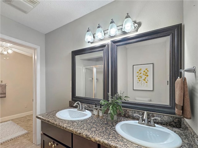 bathroom featuring vanity, a shower with shower door, toilet, and a textured ceiling