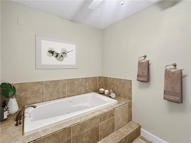 bathroom featuring a relaxing tiled tub and a textured ceiling