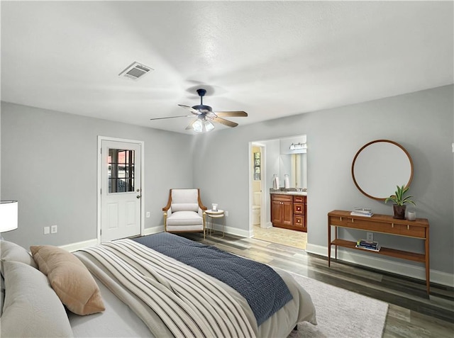 bedroom with ensuite bathroom, ceiling fan, and dark hardwood / wood-style flooring