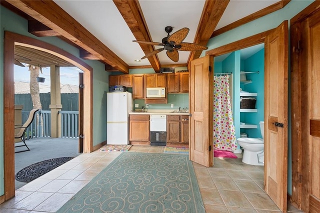 kitchen with beam ceiling, white appliances, sink, and light tile patterned floors