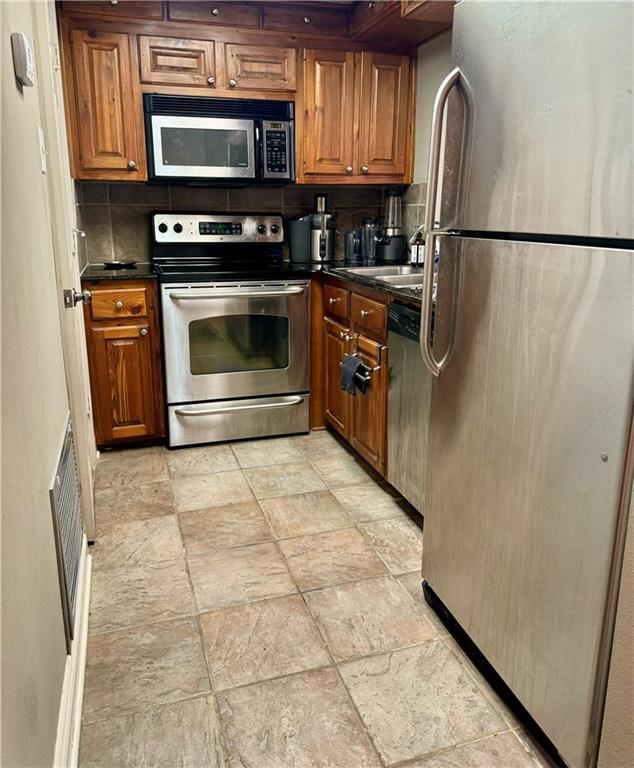 kitchen featuring tasteful backsplash, sink, and appliances with stainless steel finishes