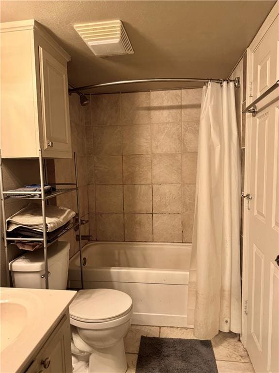 full bathroom with tile patterned floors, shower / bath combo with shower curtain, vanity, and toilet