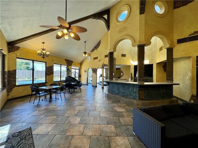 interior space featuring ceiling fan with notable chandelier and high vaulted ceiling