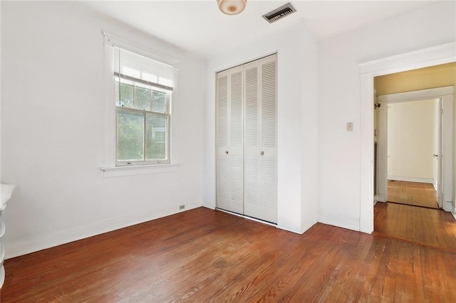 unfurnished bedroom with a closet and dark wood-type flooring