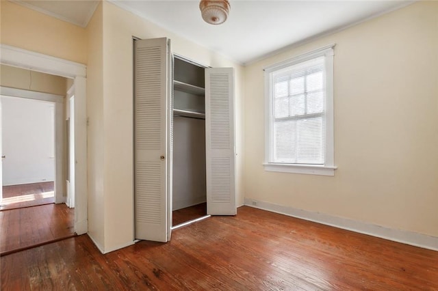 unfurnished bedroom featuring a closet and hardwood / wood-style floors