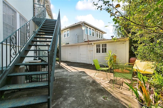 back of property with a storage shed and a patio