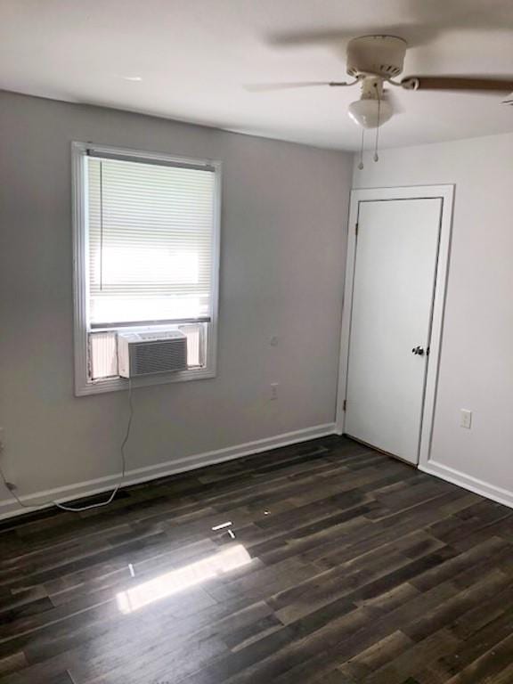 spare room featuring ceiling fan, cooling unit, and dark hardwood / wood-style flooring