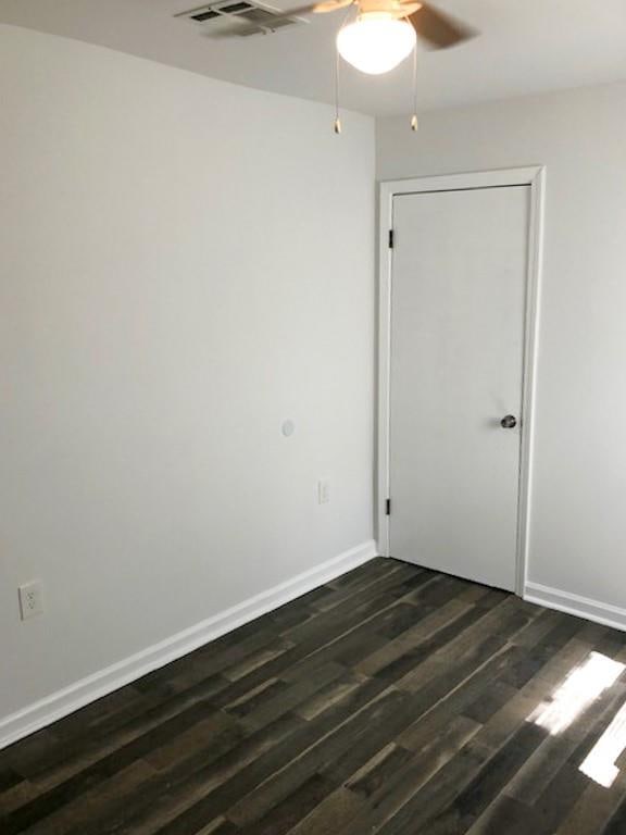 empty room featuring ceiling fan and dark hardwood / wood-style floors