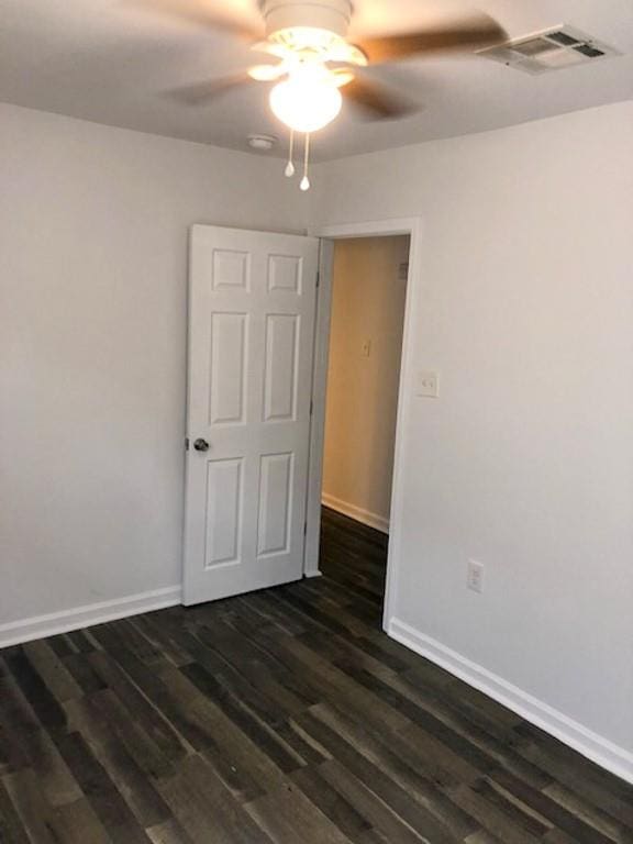 empty room featuring ceiling fan and dark hardwood / wood-style floors