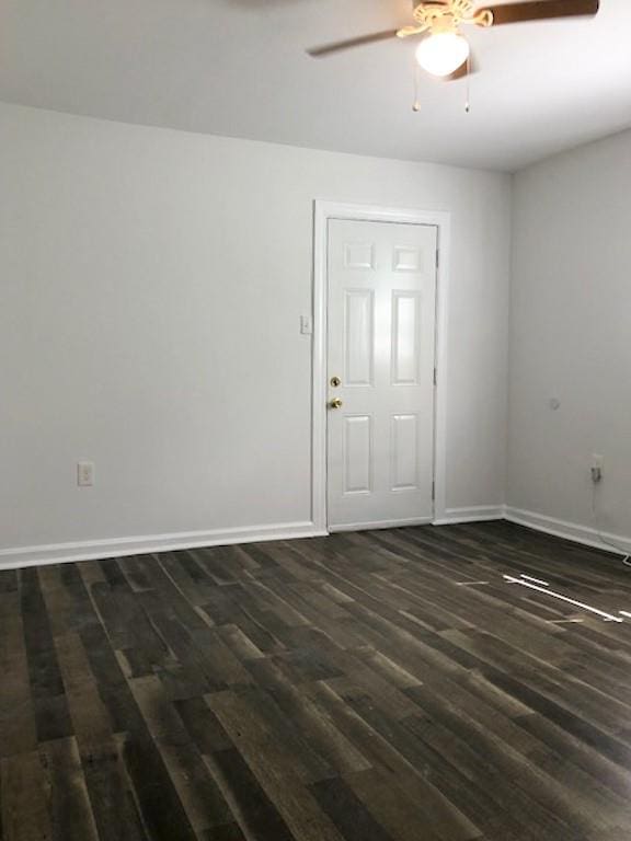 empty room featuring ceiling fan and dark wood-type flooring