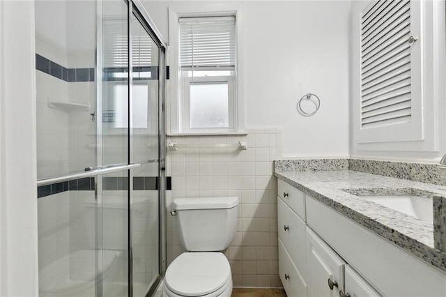2109 Airline Park Blvd, Metairie, LA 70003 - bathroom with vanity, toilet, a shower stall, tile walls, and a wainscoted wall